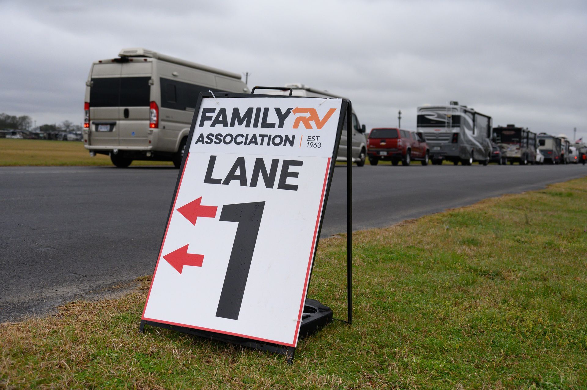 Sign for Family RV Association Lane 1 with RVs parked nearby.