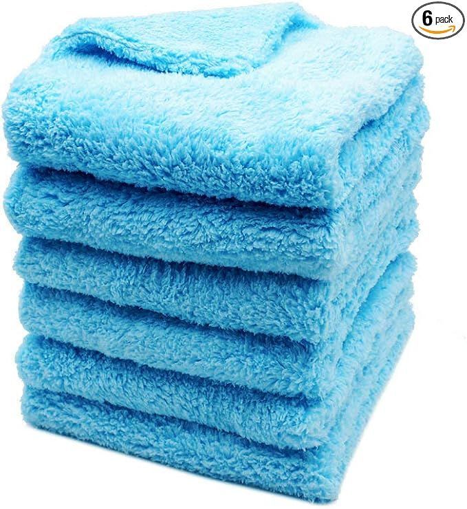 A stack of blue towels stacked on top of each other on a white background.