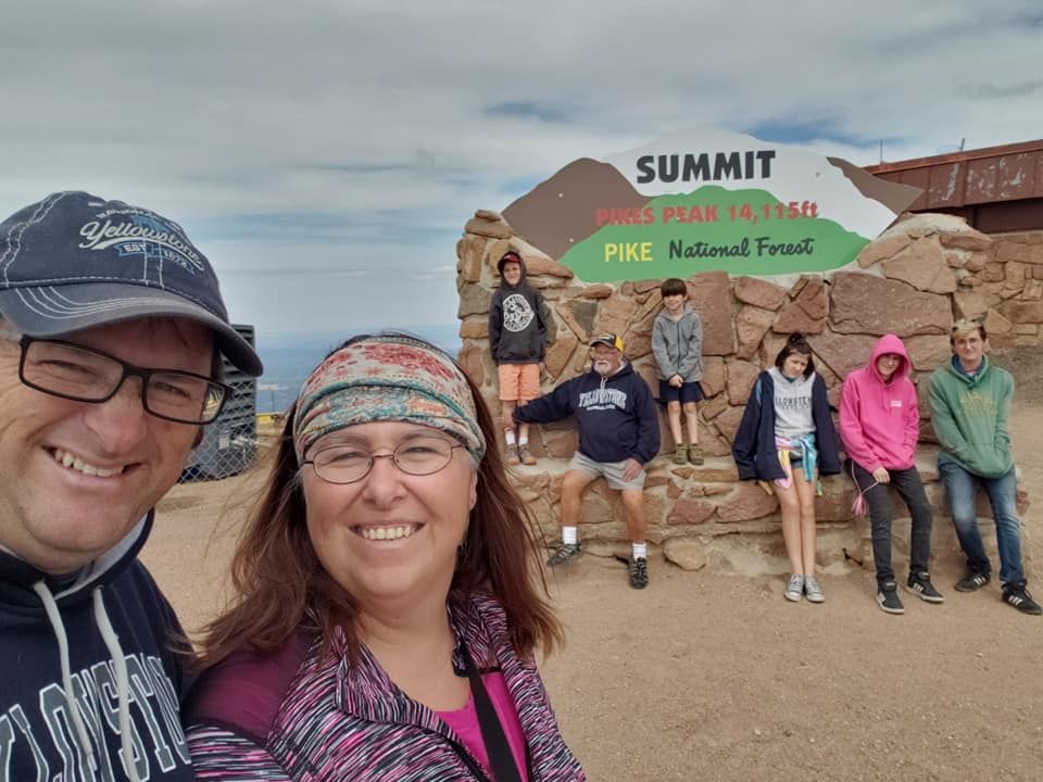 A group of people are posing for a picture in front of a sign that says summit.