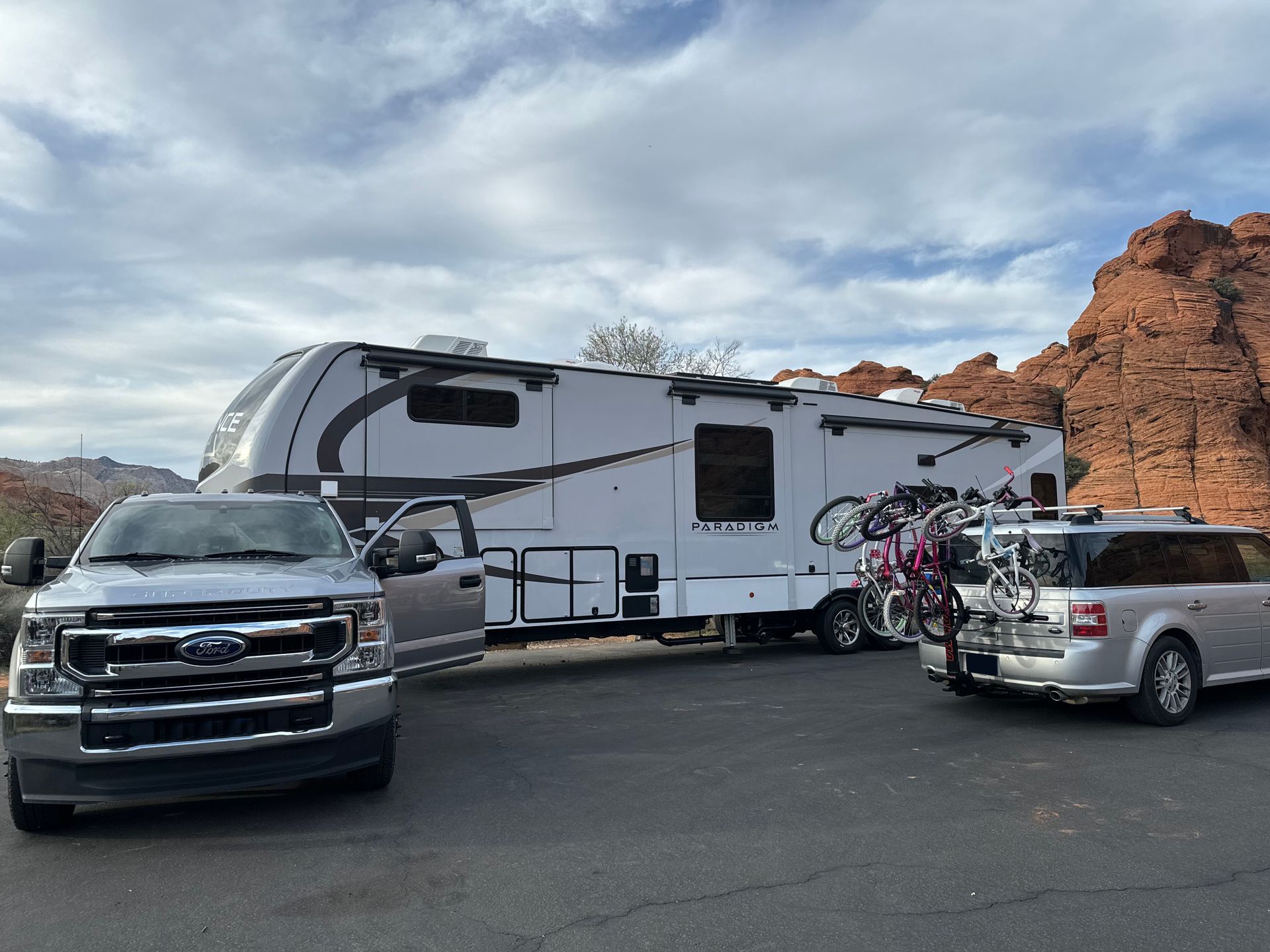 A silver ford truck is parked next to a white rv.