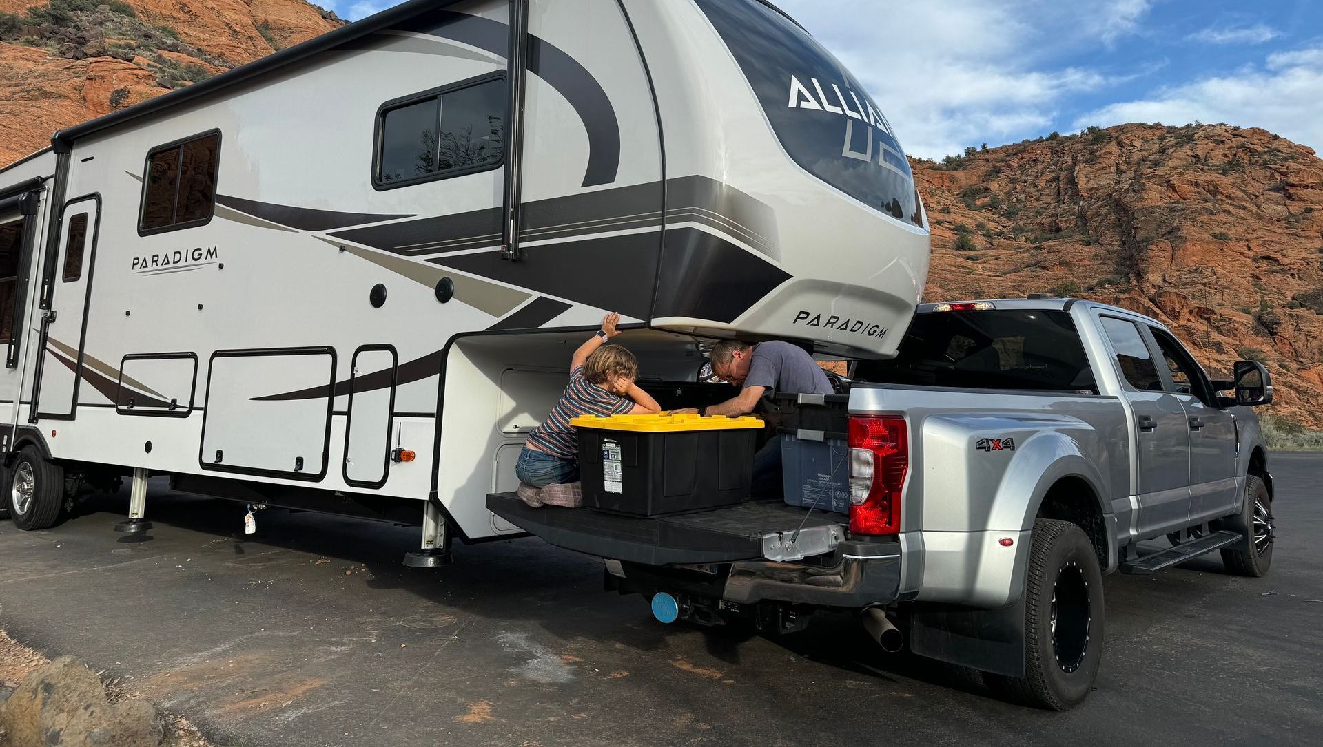 A truck is towing a rv down a road.