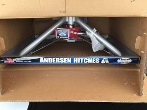 A box of andersen hitches is sitting on top of a cardboard box.
