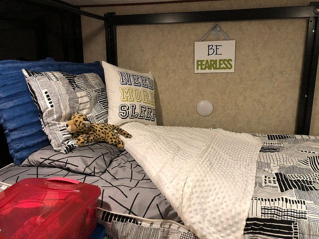 A bed with a sign that says be fearless on it