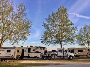 A rv is being towed by a semi truck.