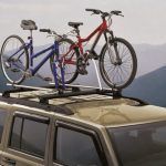 Two mountain bikes secured to a roof rack on top of a silver SUV.