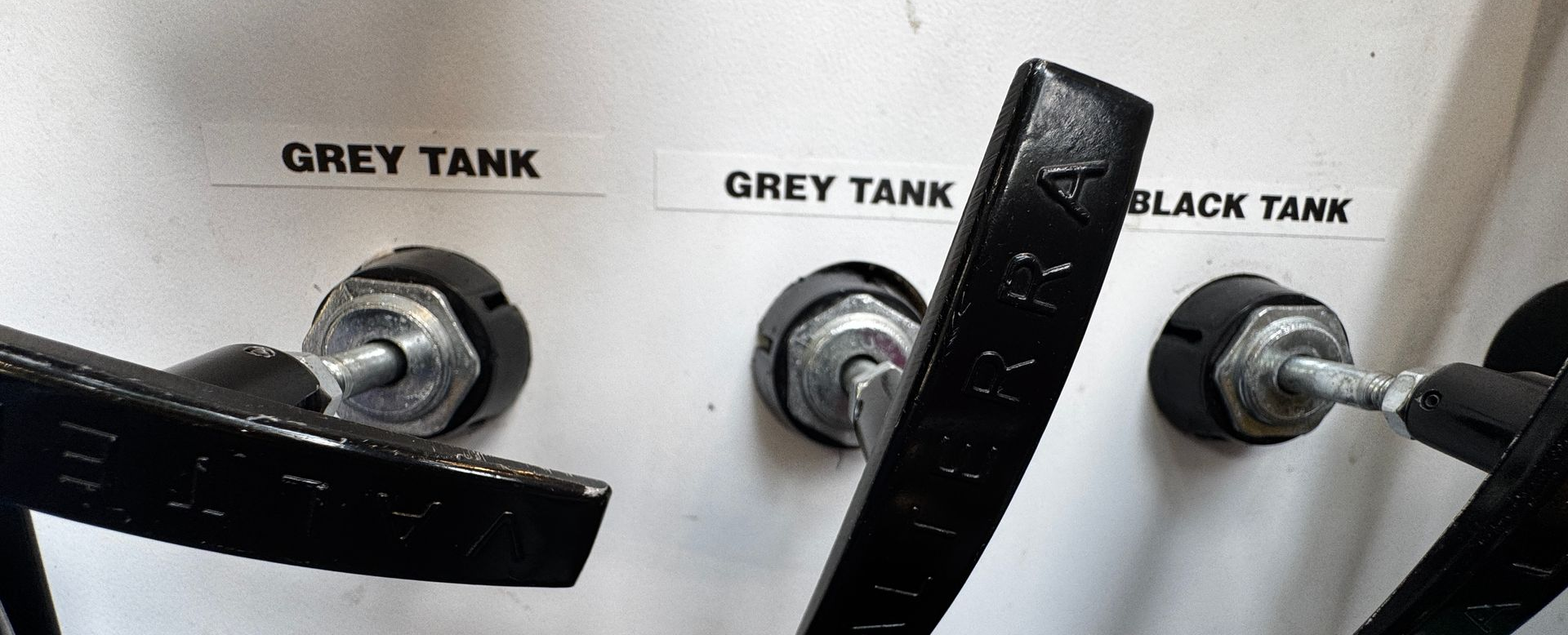 Three tank handles labeled 
