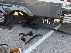 A rv is being repaired in a parking lot.