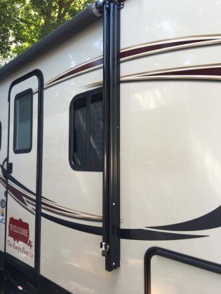 A white rv with a black pole attached to it