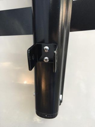 A close up of a metal pole with screws on it.