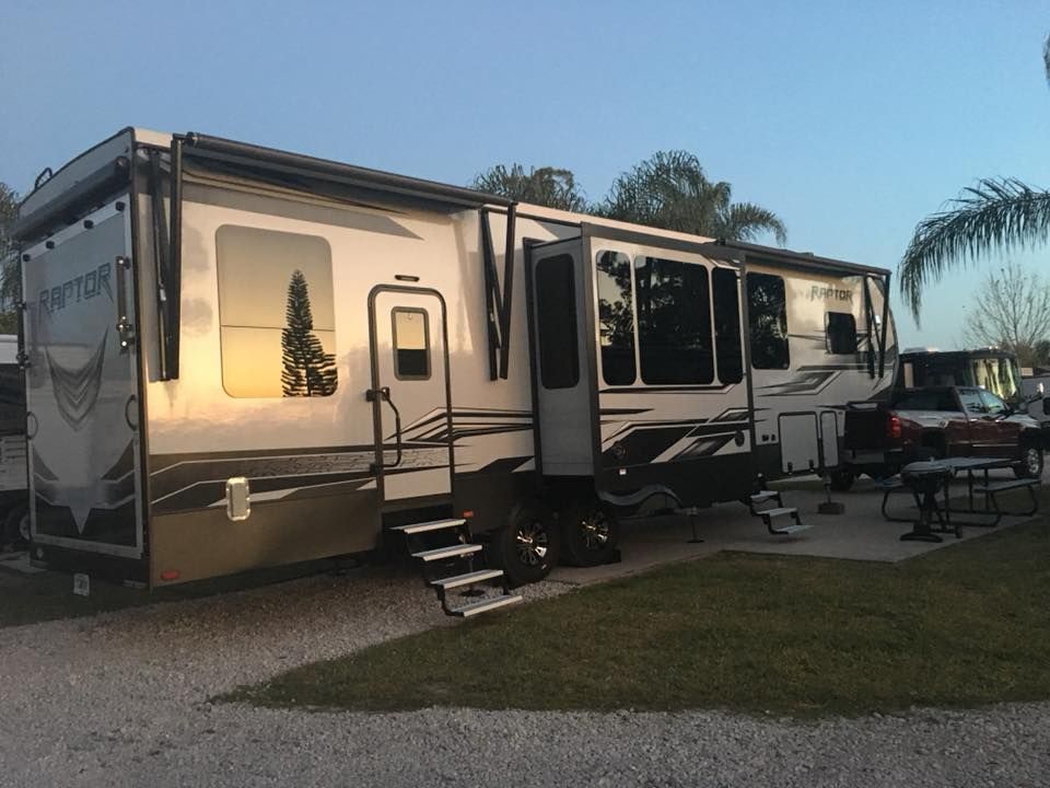 Large RV parked at a campsite, evening light reflecting on the vehicle.
