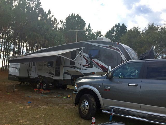 A ram truck is parked in front of a trailer