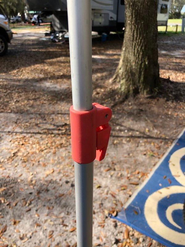 A close up of a pole with a red handle on it.