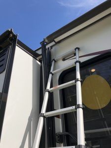 A ladder is attached to the side of a rv.