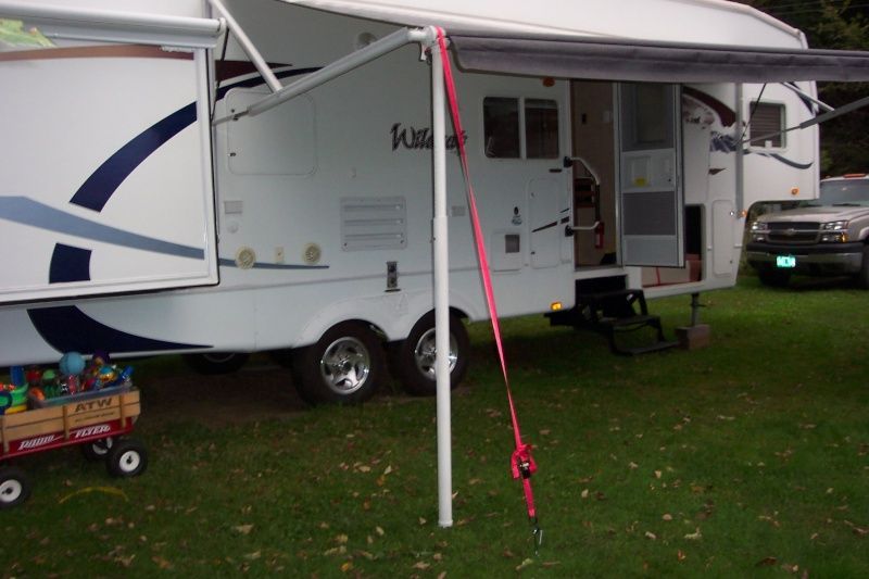 A white rv is parked in a grassy field