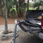 A hose is attached to the back of a truck.