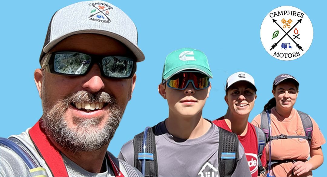 Four people with backpacks, smiling, wearing hats, in front of a blue background. Logo in upper right.