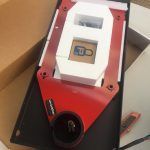 A red and white object is sitting on top of a box.