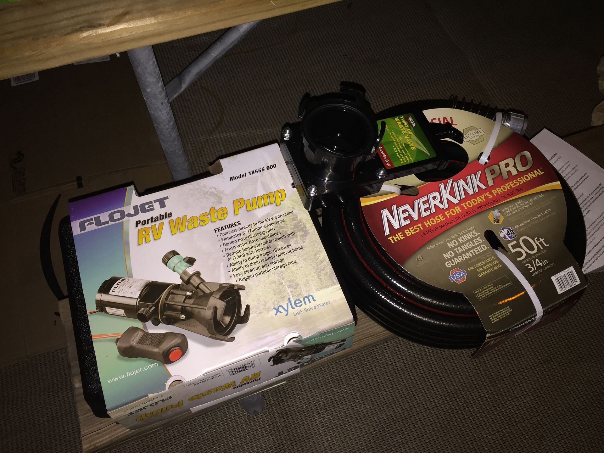 RV water pump box, NeverKink water hose, and black water inlet fitting on a surface.