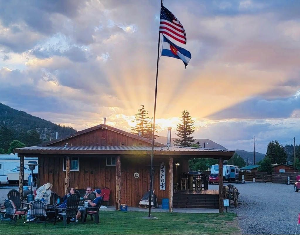 An american flag is flying in front of a wooden building