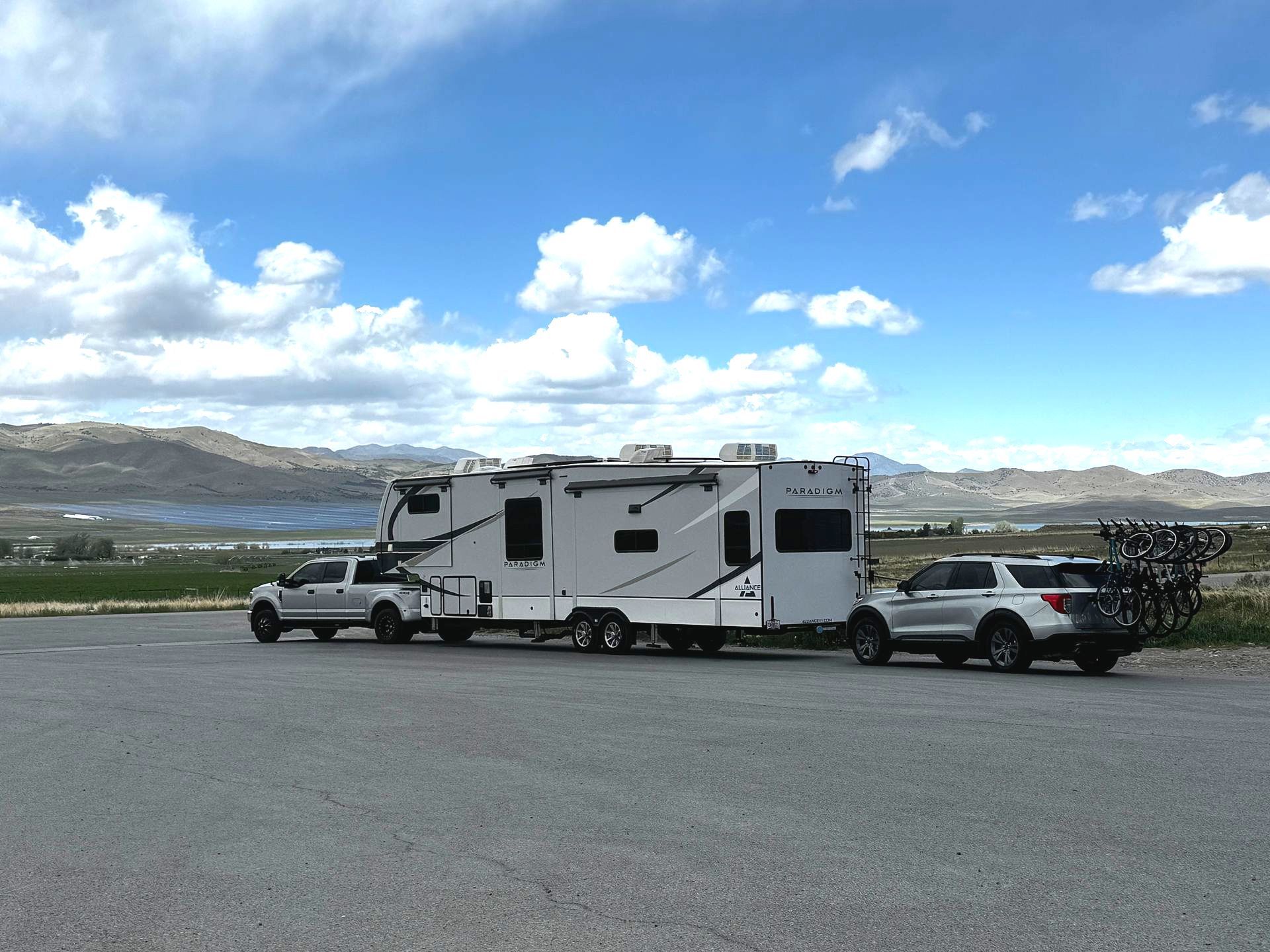 A rv is being towed by a truck in a parking lot.