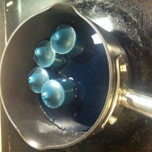 A pot filled with blue liquid is sitting on top of a stove.
