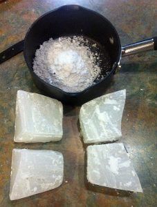 A pan filled with flour and three pieces of soap on a table.