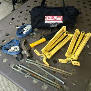 A claw bag is sitting on a table next to a bunch of tools