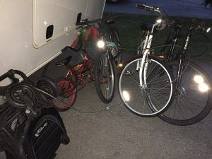A group of bicycles are parked next to a trailer.