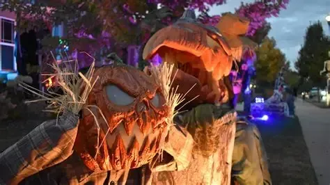 Halloween scarecrow decorations with glowing pumpkin heads.