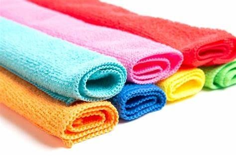 A bunch of colorful towels are stacked on top of each other on a white background.