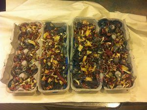 Three trays of food are sitting on a table.