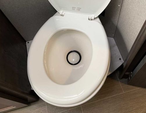 Open toilet seat showing a clean white toilet bowl in a restroom