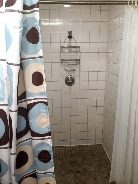 A shower with a shower curtain that has circles on it