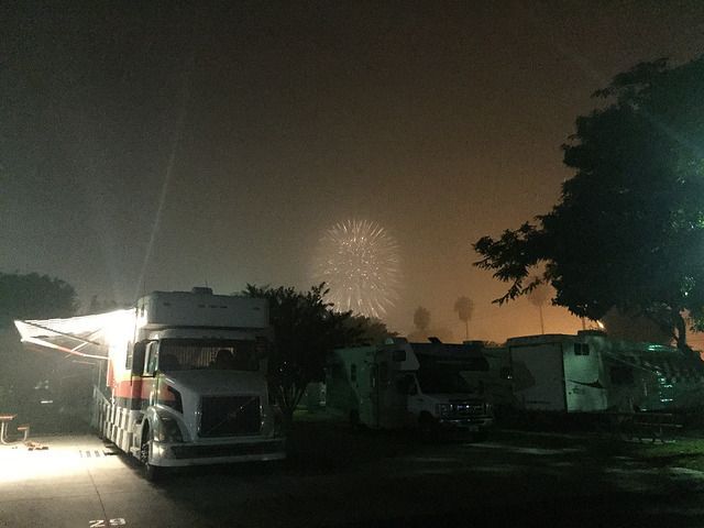 A rv is parked in front of a fireworks display.