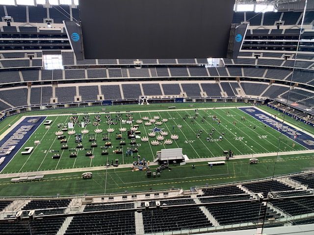 Empty football field with tables set up, inside AT&T Stadium.