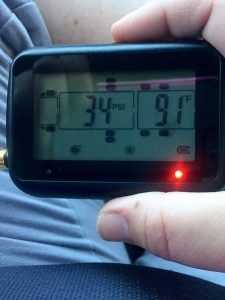 A person is holding a digital thermometer that reads 34 degrees