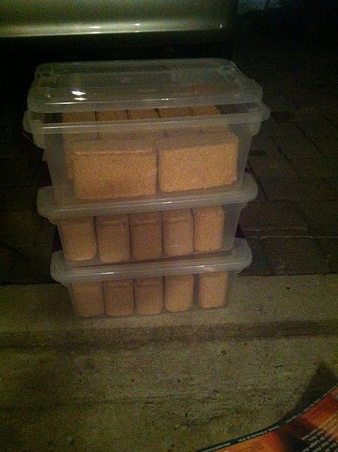 Three plastic containers are stacked on top of each other on the ground.