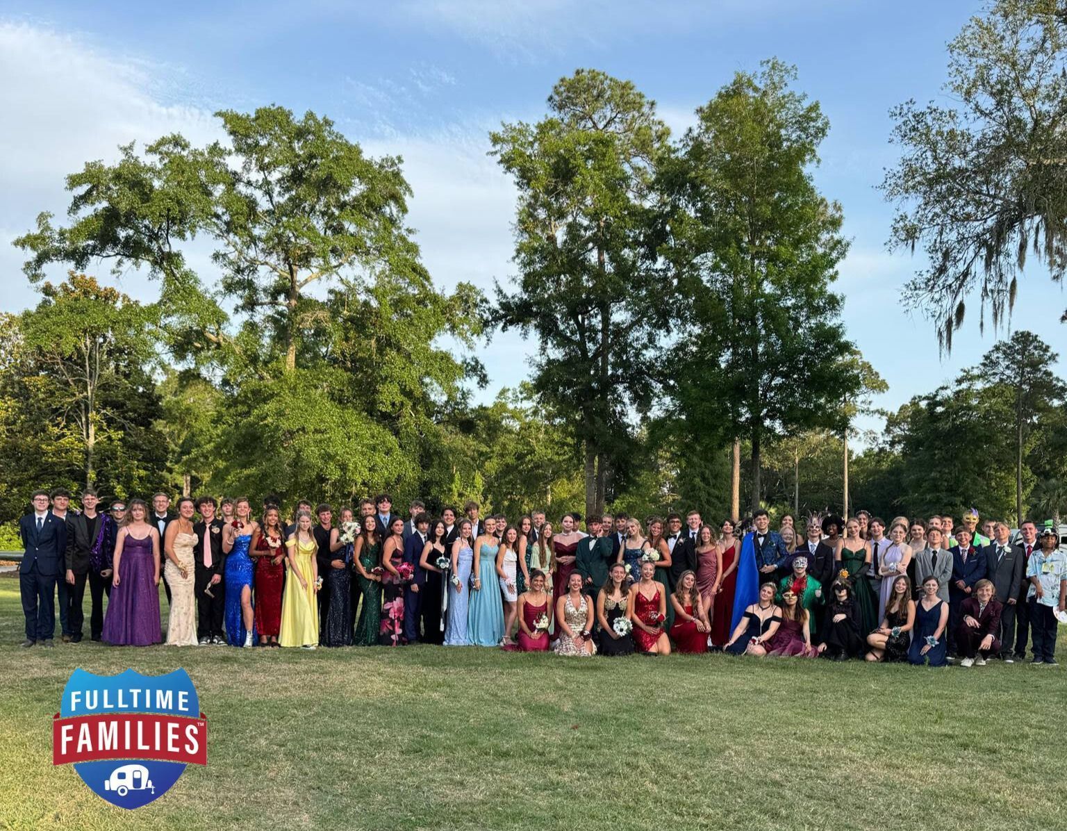 A large group of people are posing for a picture in a park.