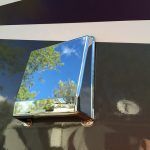 A picture of a blue sky and trees is hanging on a wall.