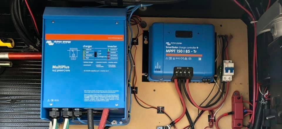 Blue Victron Energy devices with wiring inside a compartment.