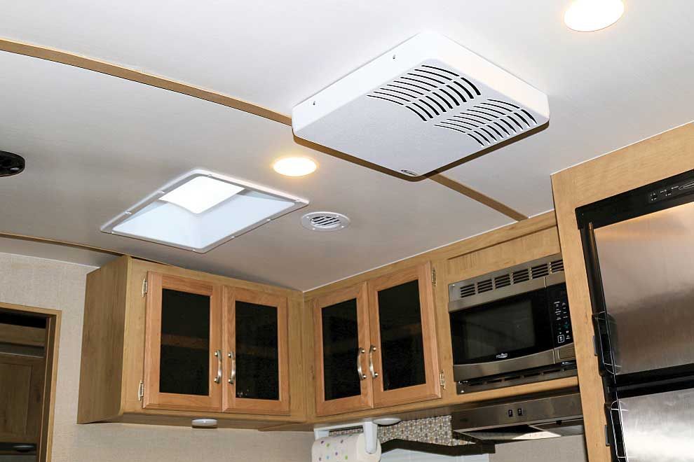 A kitchen with wooden cabinets and a ceiling fan