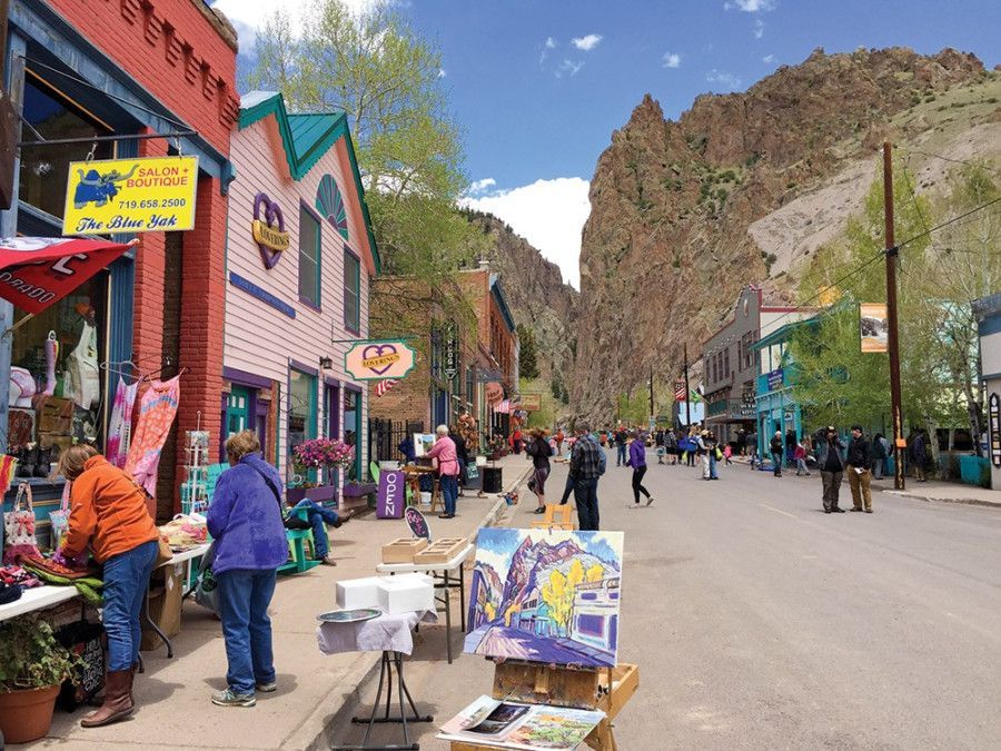 People are walking down a street in a small town.