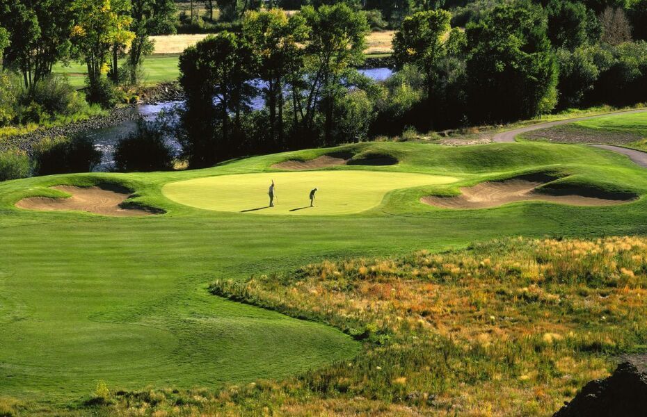 A couple of people are playing golf on a golf course