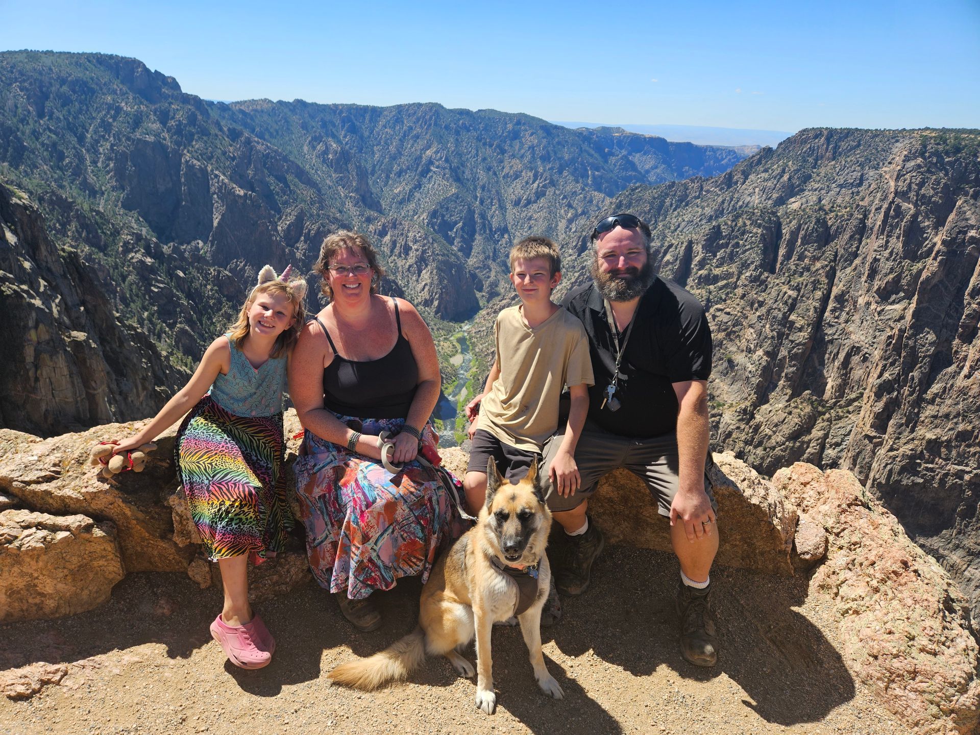 Family of 4 photo with dog and a mountain background