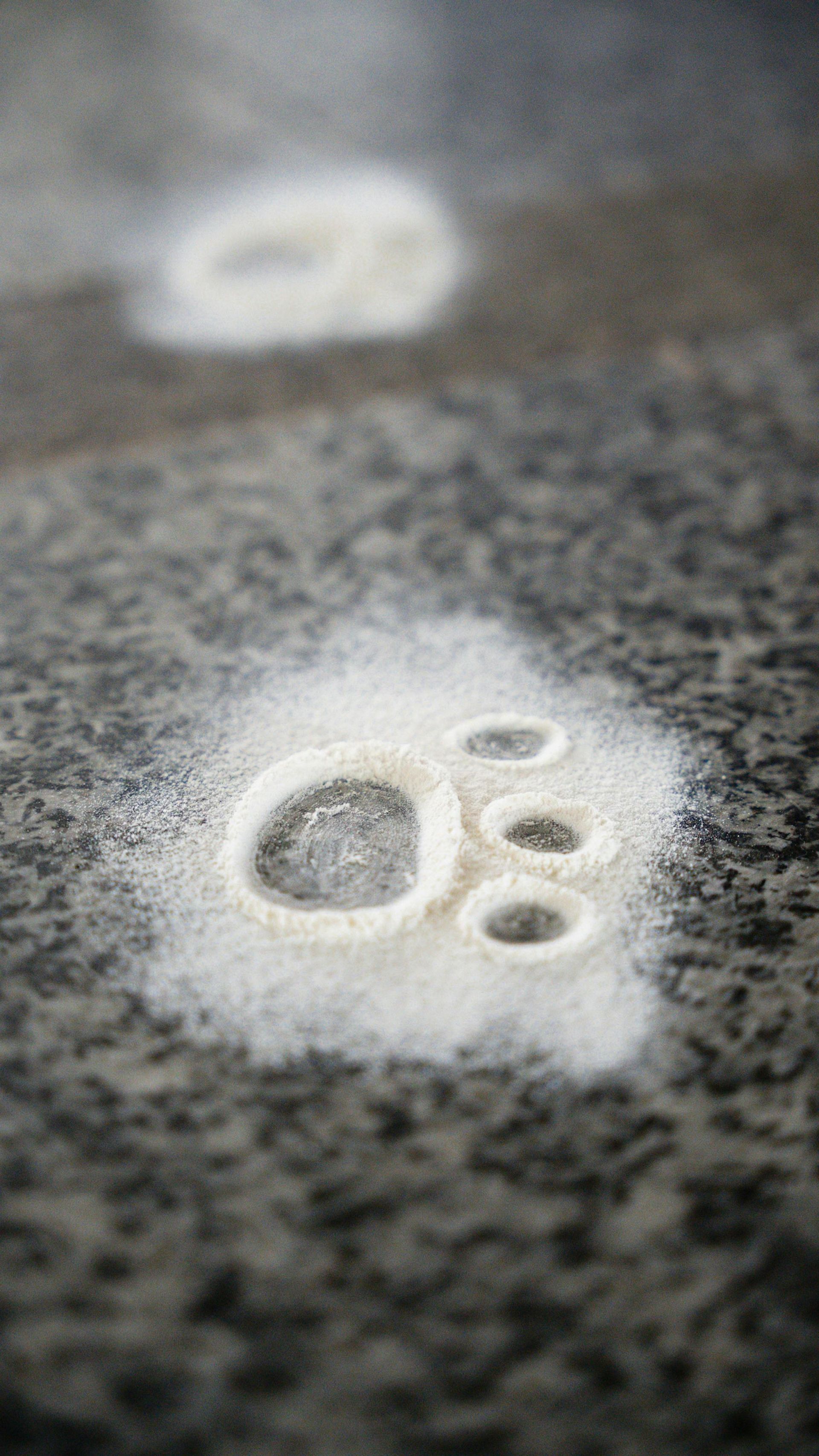 White powder footprint on a speckled, gray surface.