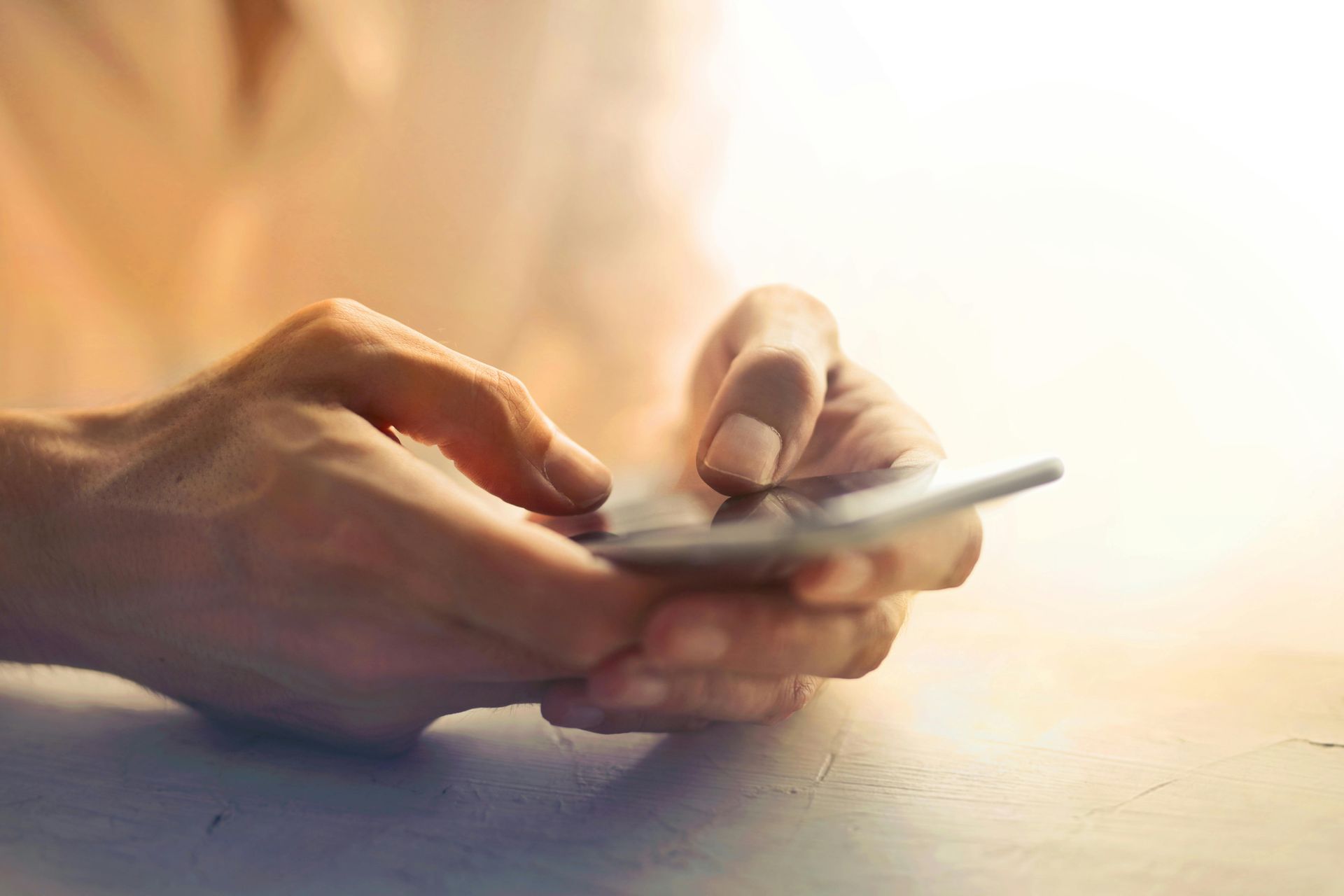 Hands holding a smartphone, with a finger touching the screen.
