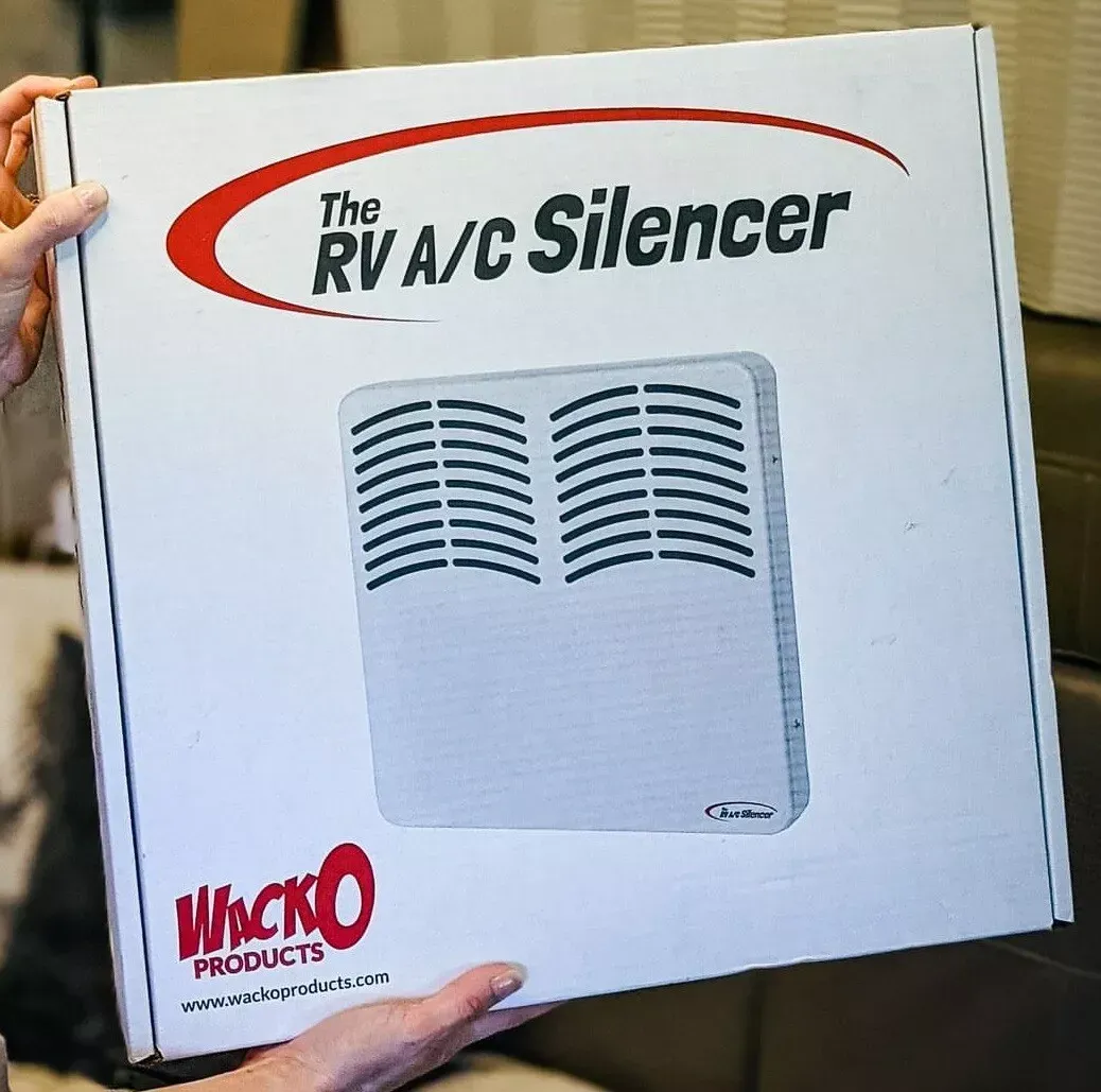 A person is holding a box that says the rv a / c silencer