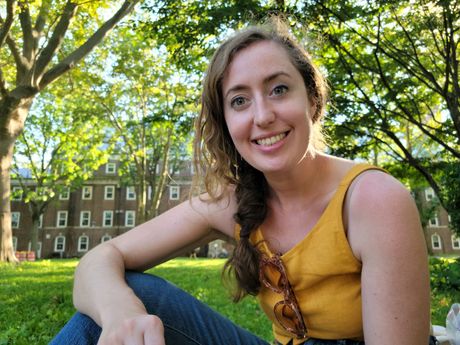 Casual portrait of Jenny seated and smiling in a park. 