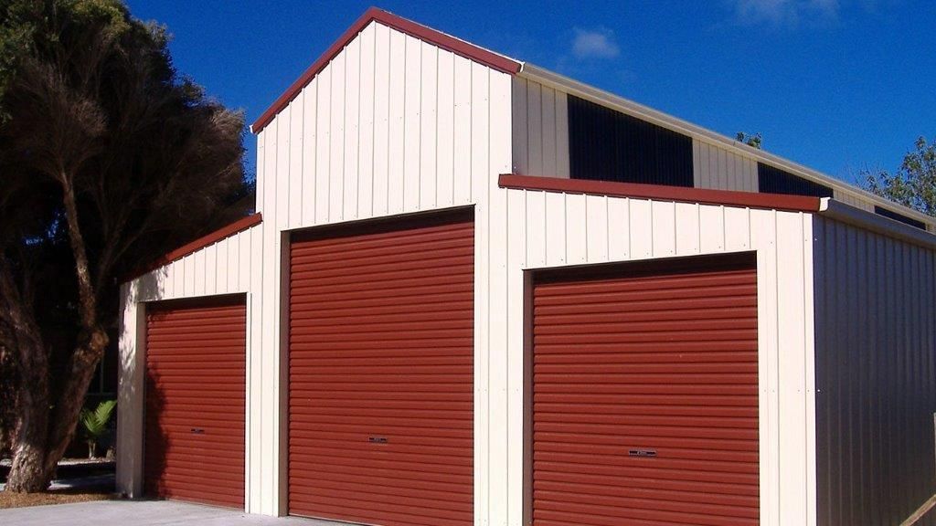 A white barn with three red garage doors — More Than Garages Pty Ltd–Ranbuild Tamworth in Taminda, NSW