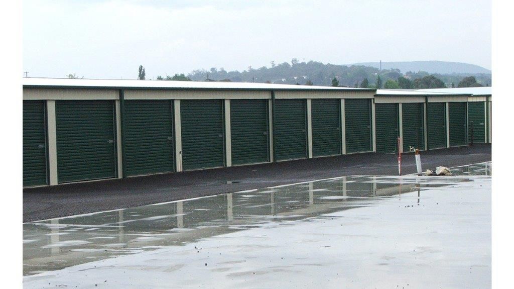 A White Building With A Green Roof And A White Garage Door — More Than Garages Pty Ltd–Ranbuild Tamworth in Taminda, NSW